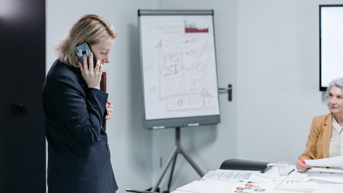 Frau telefoniert während eines Meetings