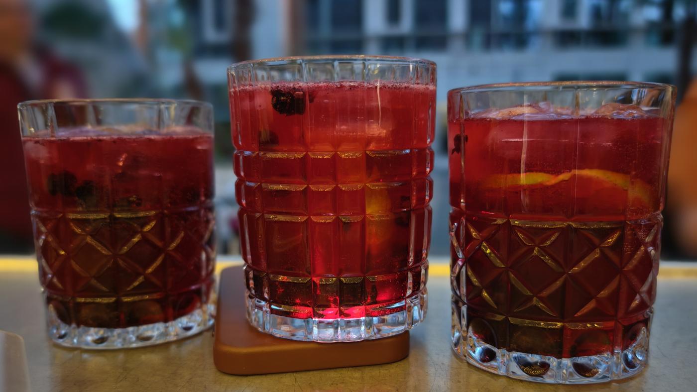 Drei Gläser mit einem roten Getränk und Früchten stehen auf einem Tisch